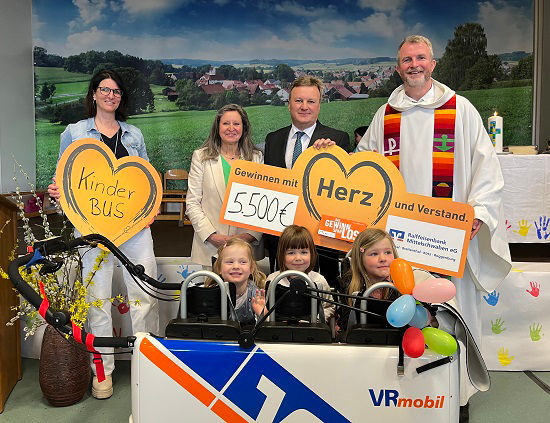 Foto von Kindern und Erwachsenen, die sich freuen, weil sie Geld für einen Kinderbus gesammelt haben