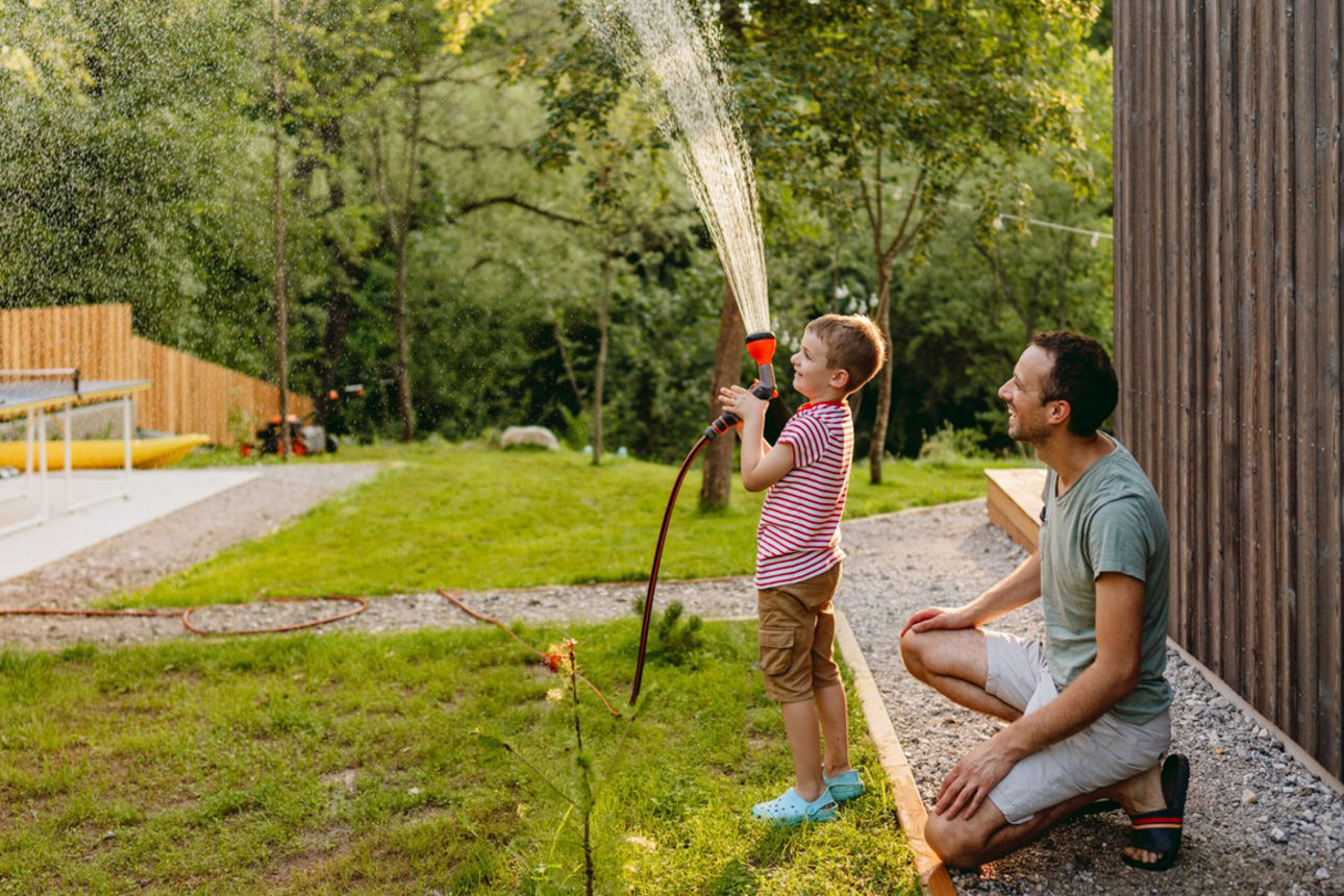 Junges Kind spielt zusammen mit Vater im Garten