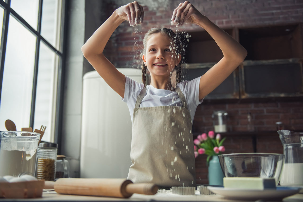 Kleines Mädchen lächelt beim Backen
