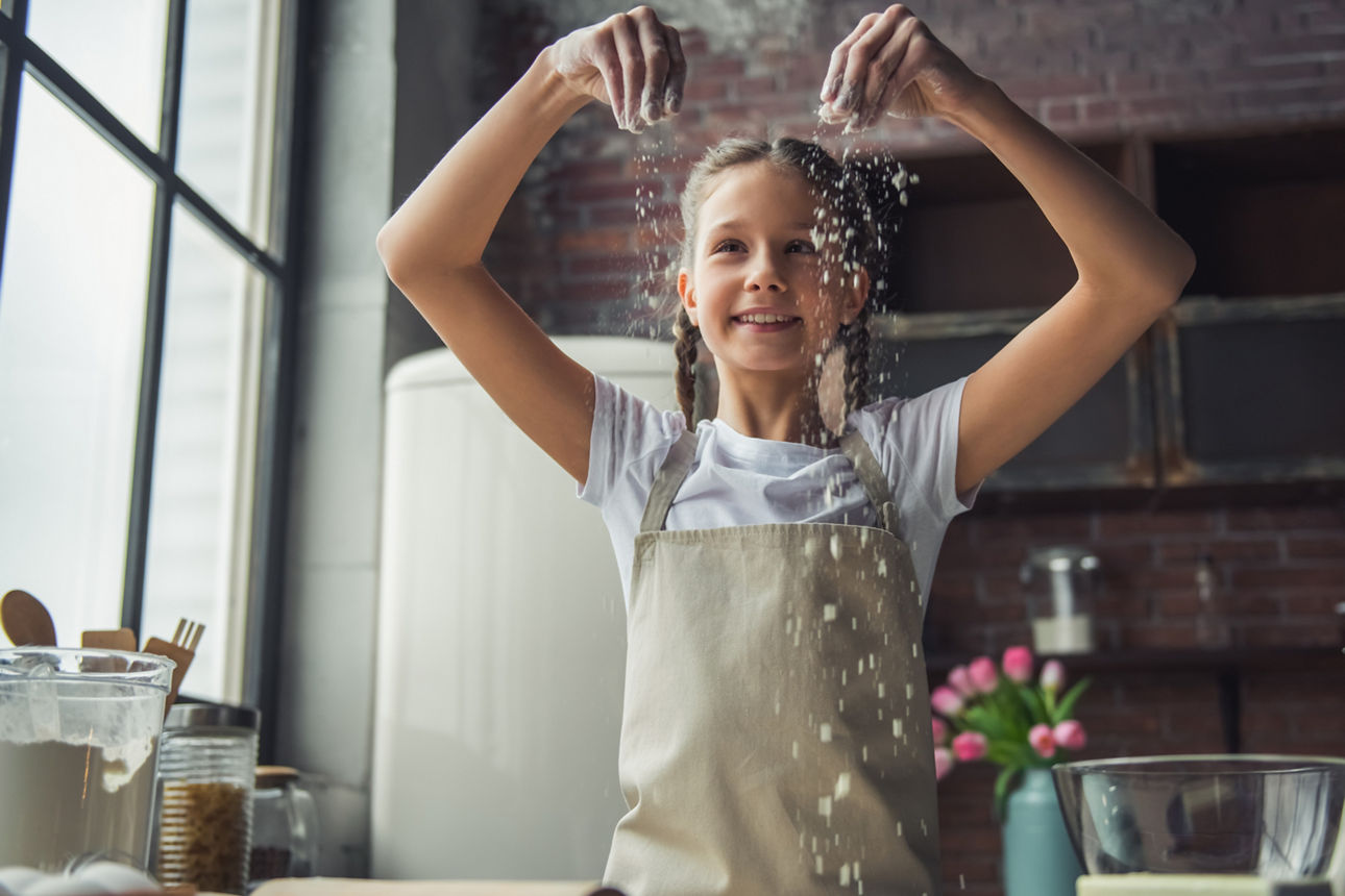 Kleines Mädchen lächelt beim Backen