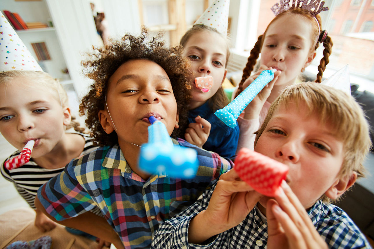 Verschiedene Kinder die Tröten im Mund haben