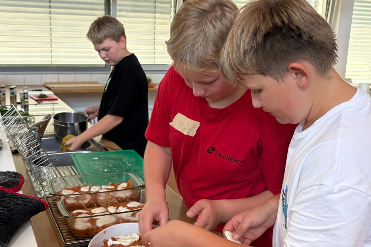 Jungsgruppe belegt Hackbällchen mit Käse