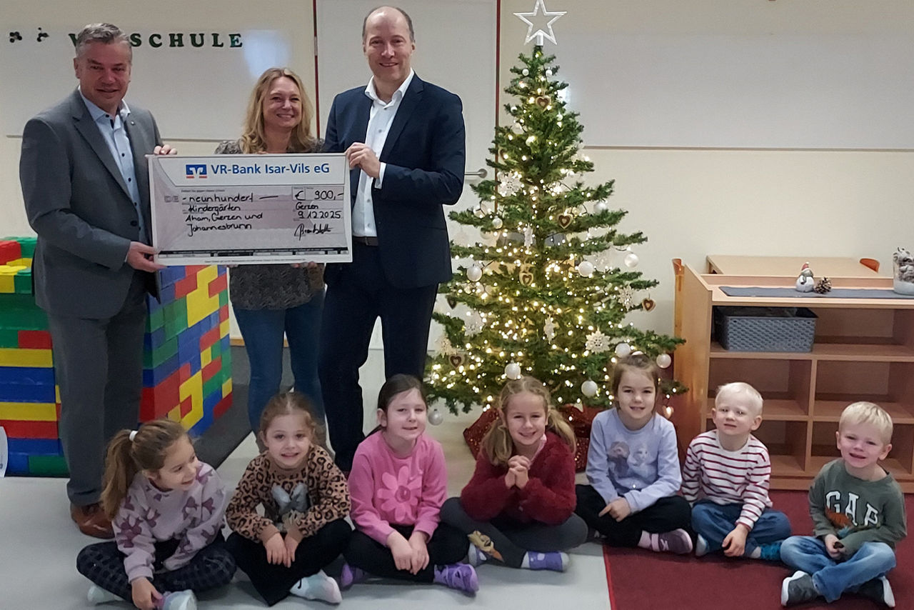 Eine Frau und zwei Männer umgeben von Kindern lachen in die Kamera. Sie halten einen Riesenspendenscheck in der Hand.