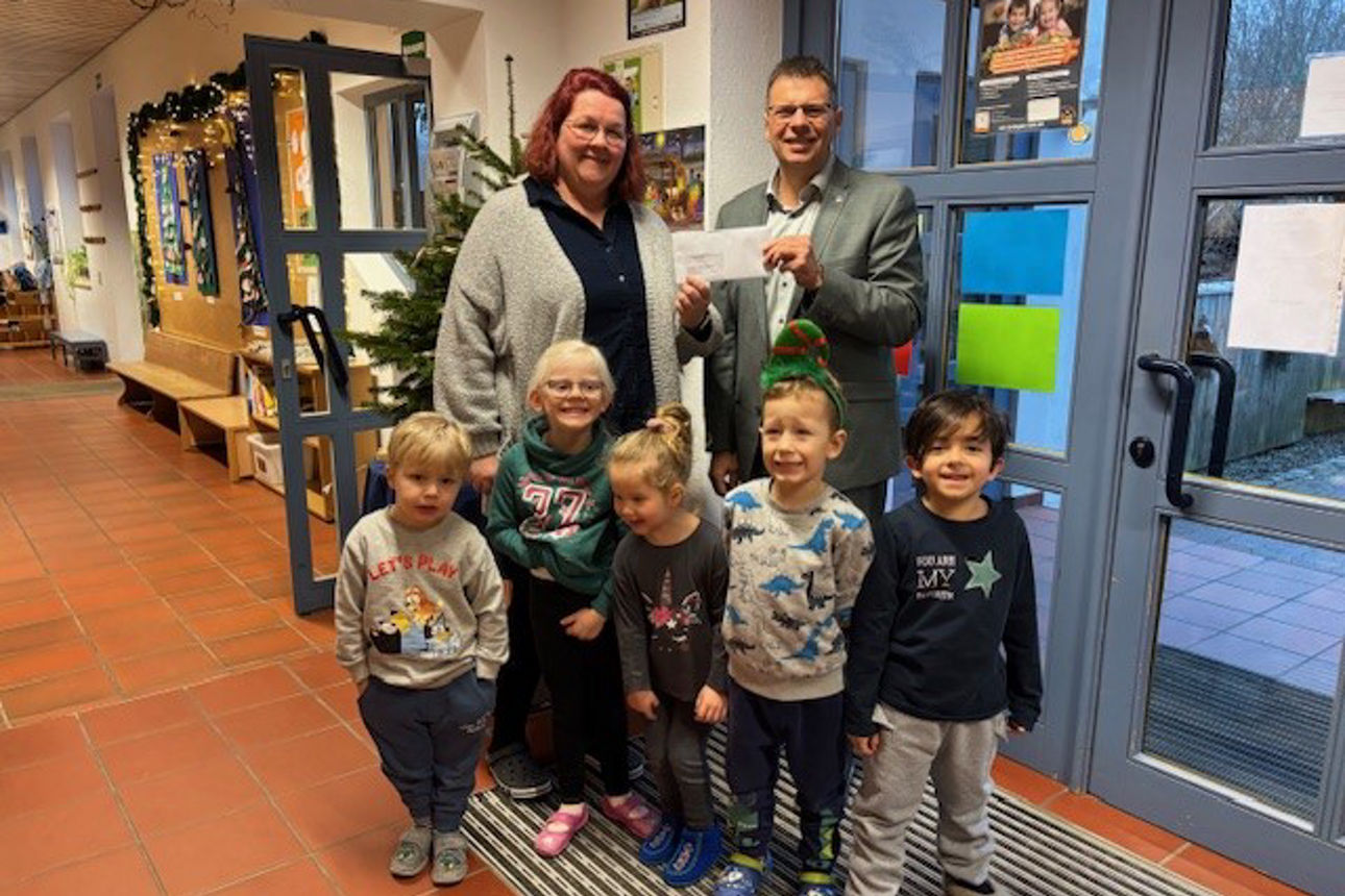 Eine Frau, fünf Kinder und ein Mann stehen vor einem Christbaum und lächeln in die Kamera.