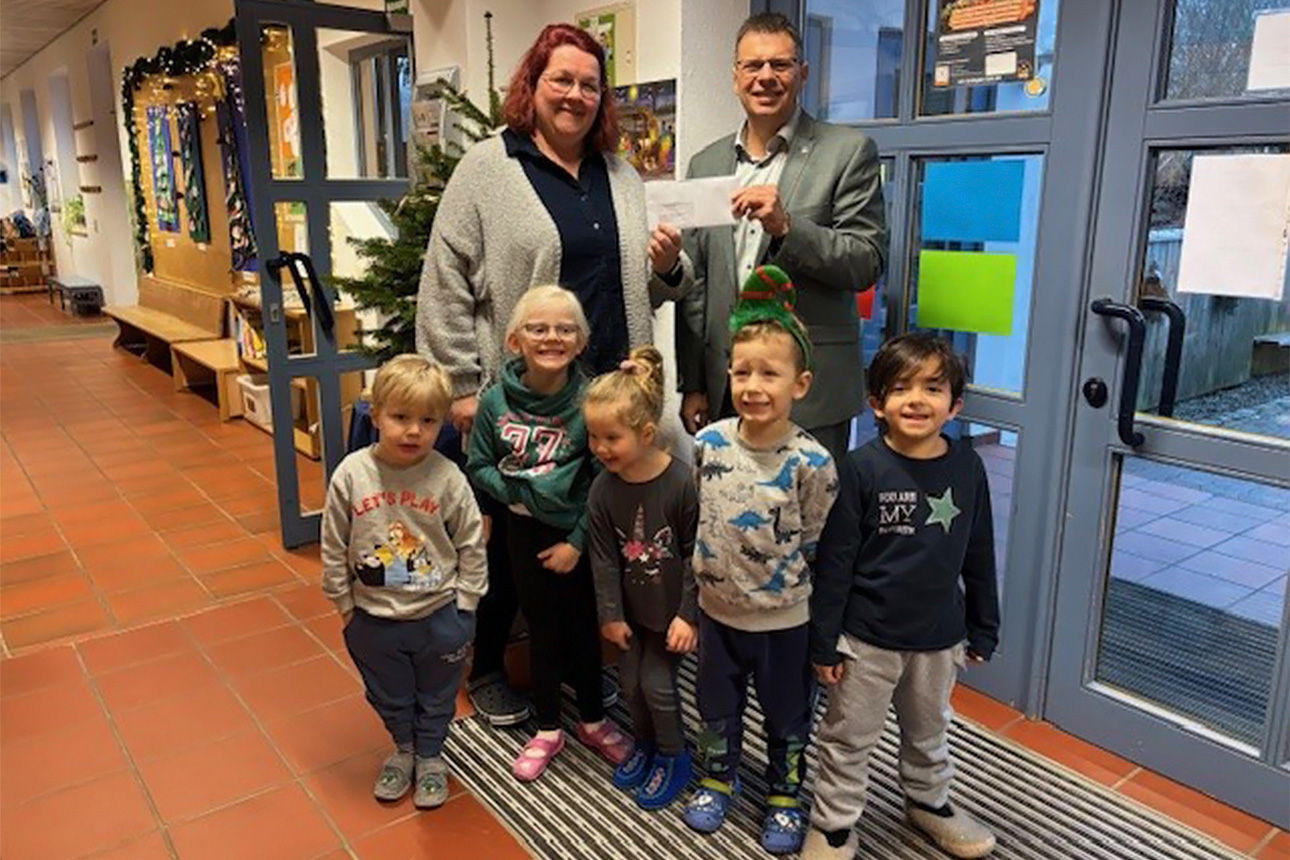 Eine Kindergärtnerin posiert mit ihren Kindergarten Kindern für ein Bild