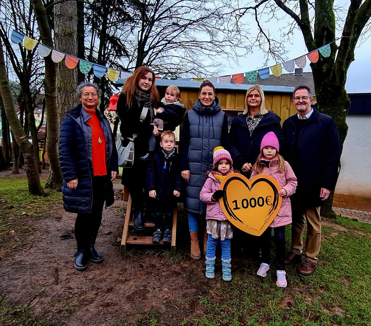 Auf dem Bild sind die Kindergartenleitung und der Spendenbotschafter zusammen mit den Mitgliedern des Elternbeirats zu sehen.