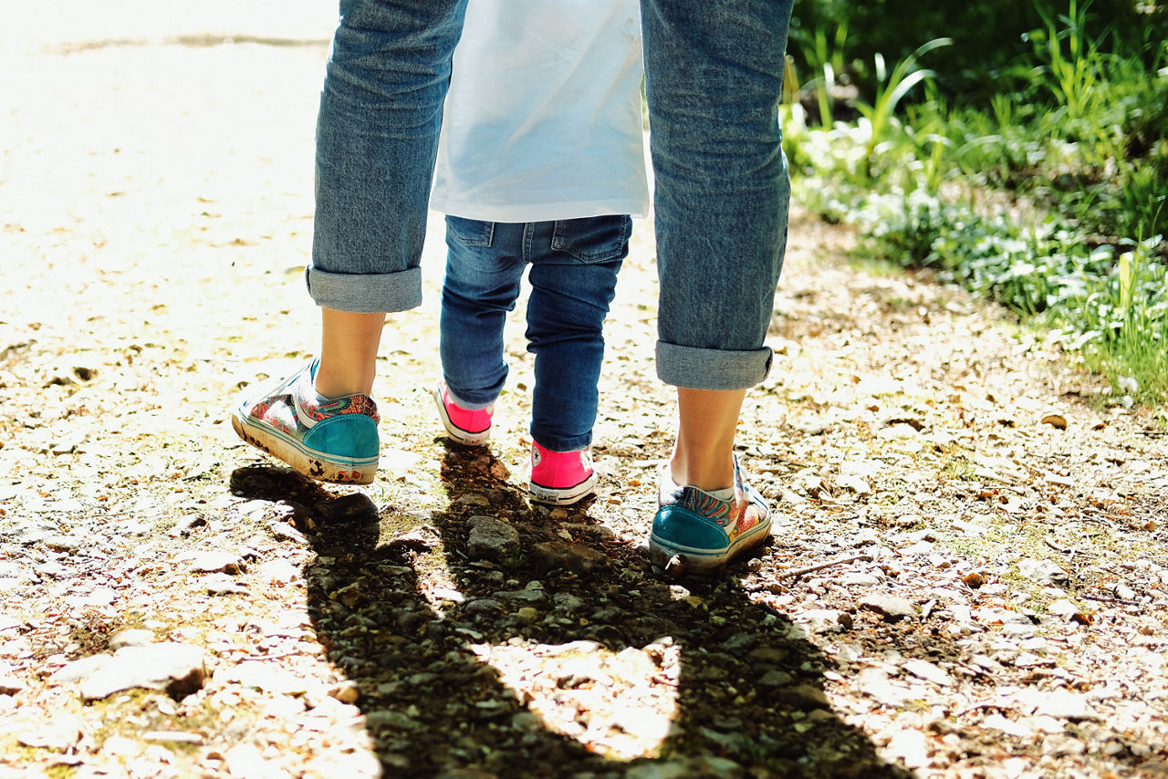 Mutter und Kind gehen auf einen Feldweg