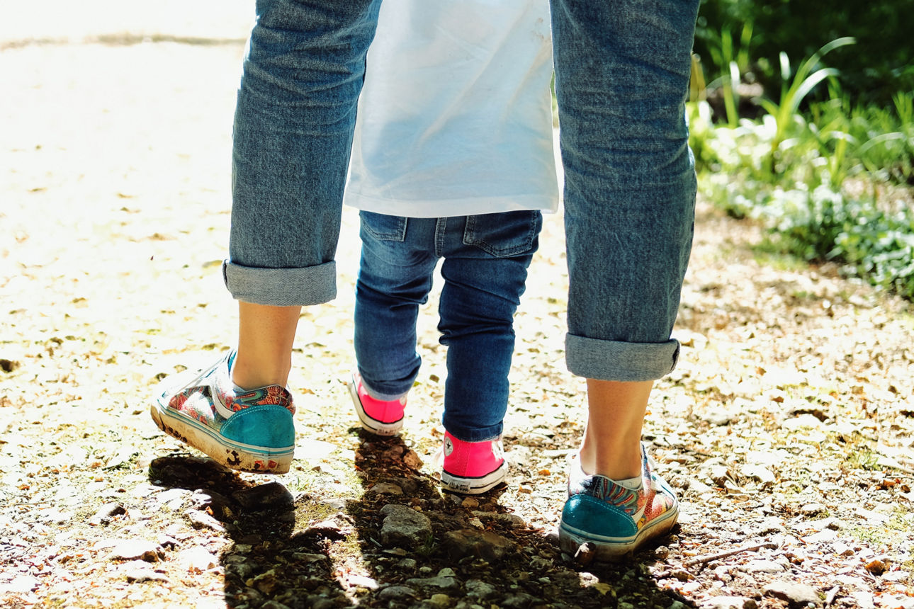 Mutter und Kind gehen auf einen Feldweg