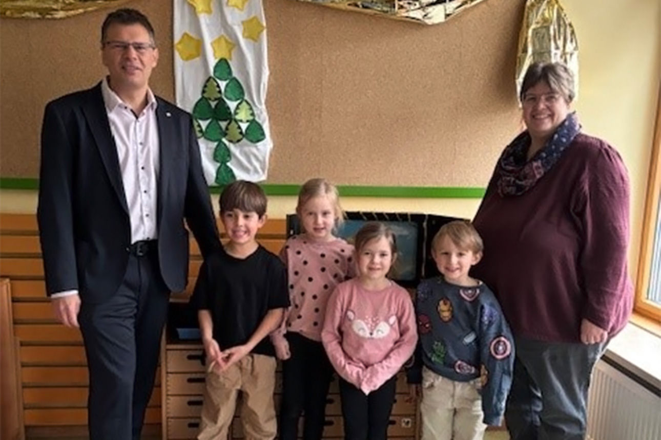 Ein Mann, eine Frau und vier Kinder lachen in die Kamera.