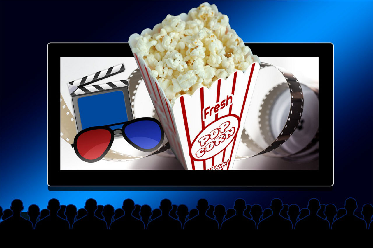 Kinoleinwand mit Publikum und Popcorn