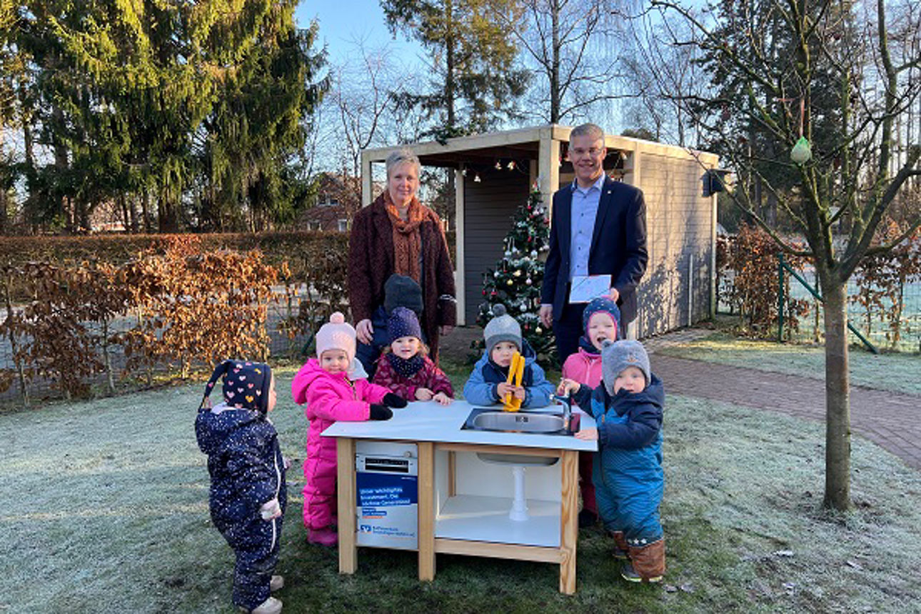 5 Kinder, Herr Nowak und Frau Lüken draußen an der Matschküche