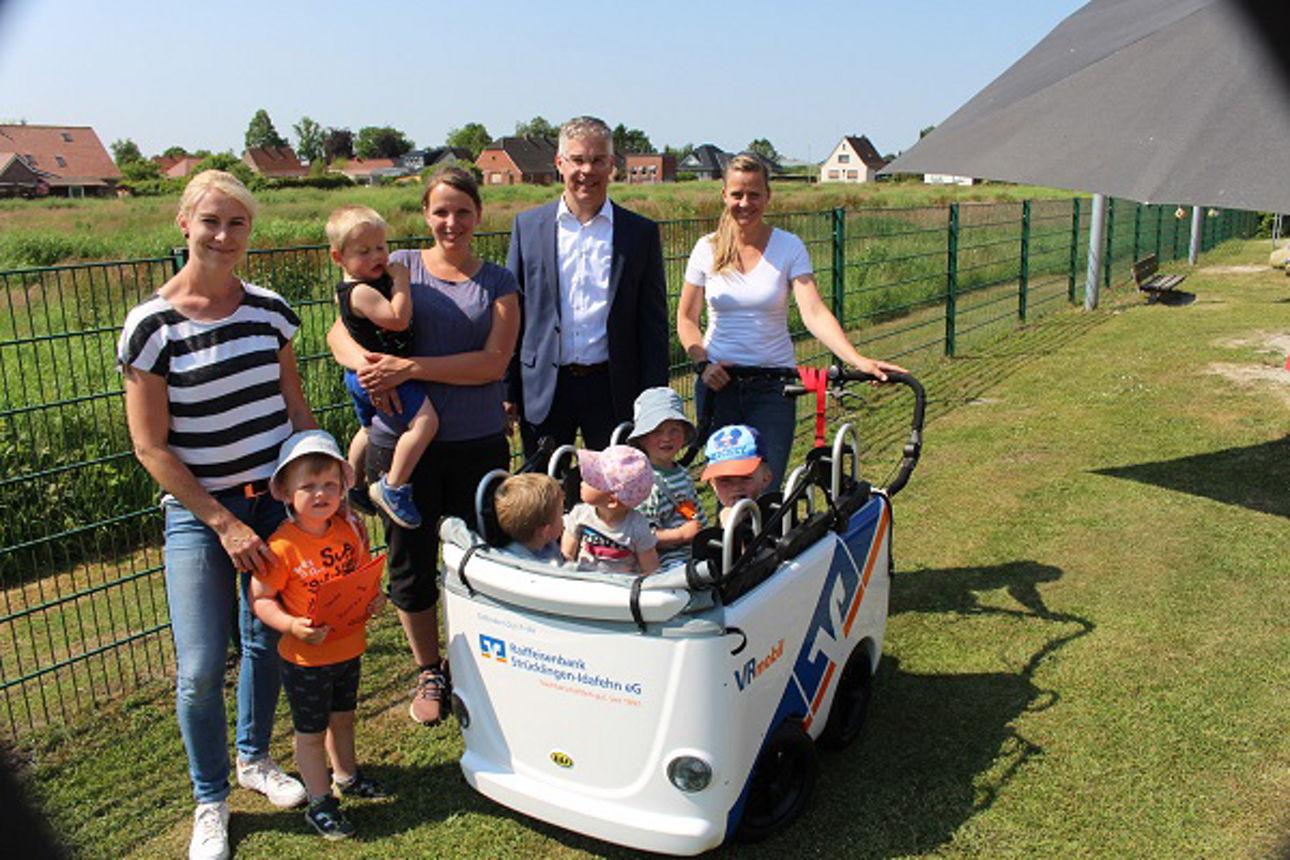 Kleine Gruppe von Kindern, Vorstand und Erzieherin an der Matschküche 