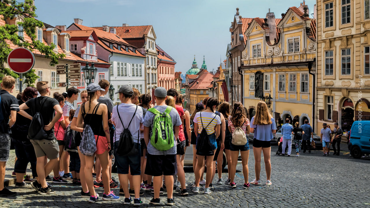 eine Gruppe Jugendlicher hört bei einer Stadtrundführung zu