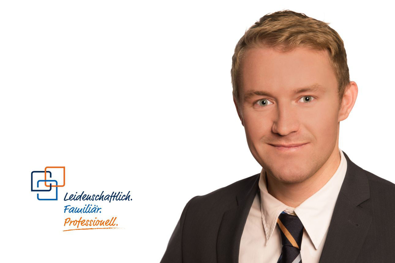 Porträt von Klaus Kinshofer, einem lächelnden jungen Mann mit blonden Haaren im dunklen Anzug mit gestreifter Krawatte. Daneben das Firmenlogo und der Slogan "Leidenschaftlich. Familiär. Professionell."