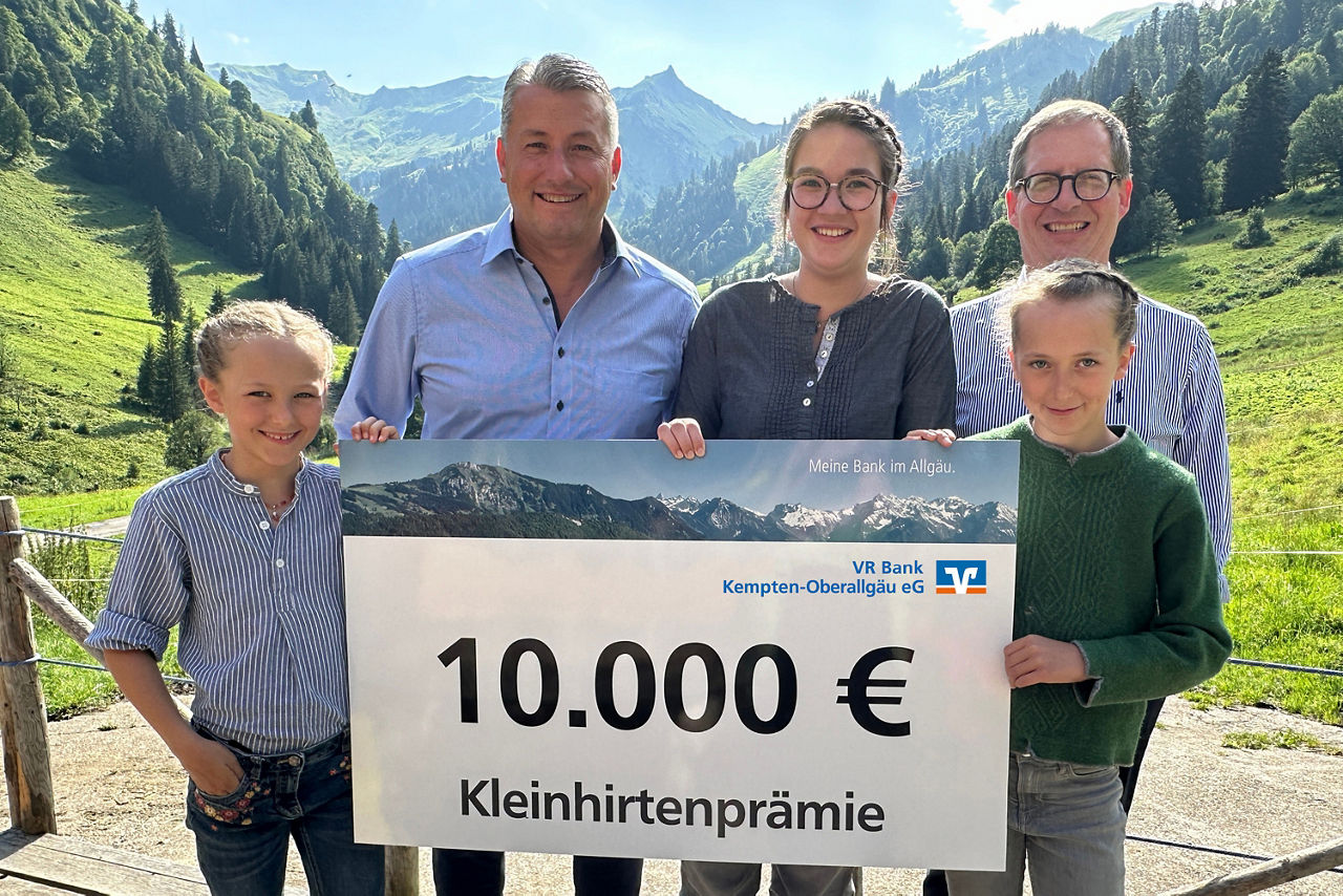 Kleinhirtenpraemie - Vorstand der VR Bank mit drei Kleinhirtinnen auf einer Alpe - im Hintergrund sind die Allgäuer Berge zu sehen