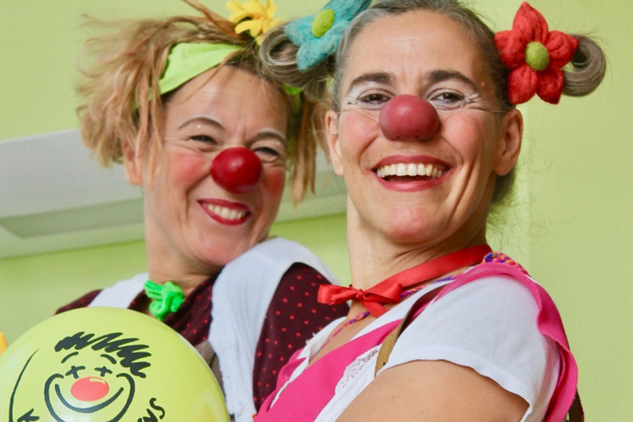 Gruppenbild von 2 Frauen mit einigen Kindern, die neue Schulranzen geschenkt bekommen