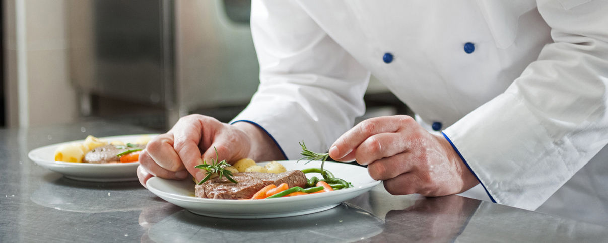 Detail wie Hände einen Teller mit einem Steak dekorieren