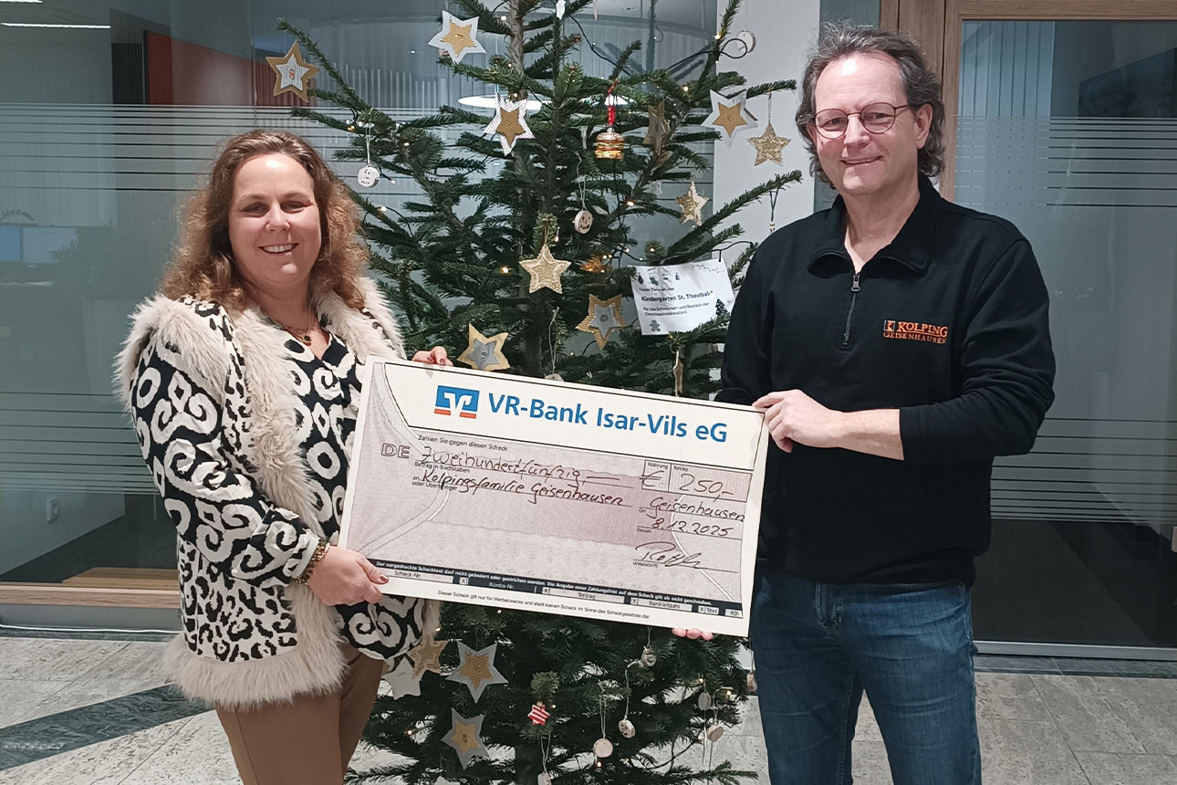 Eine Frau und ein Mann lächeln in die Kamera. Sie halten einen Riesenspendenscheck in der Hand.