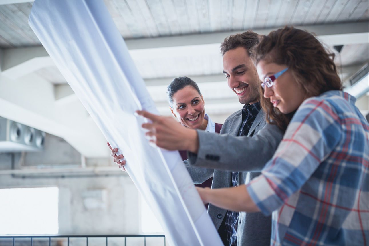 Zwei Frauen und ein Mann schauen einen Plan an