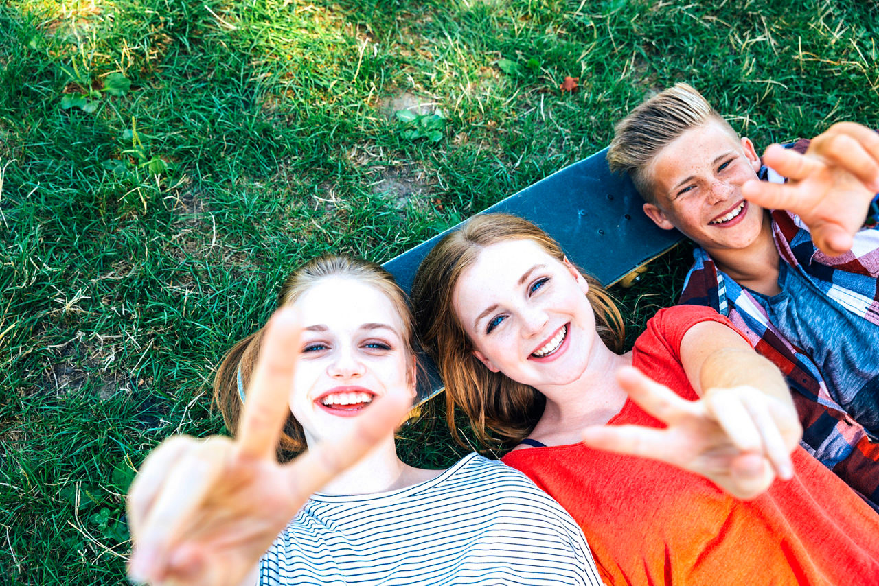 Drei Teenager liegen auf dem Boden und sind glücklich 