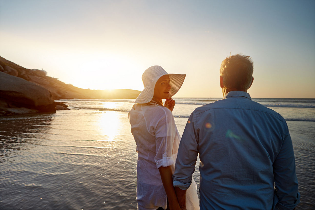Frau mit Mann am Meer im Sonnenuntergang