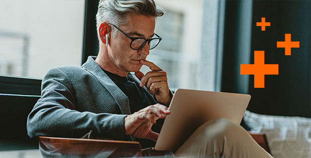 Mann schaut konzentriert in eine Laptop