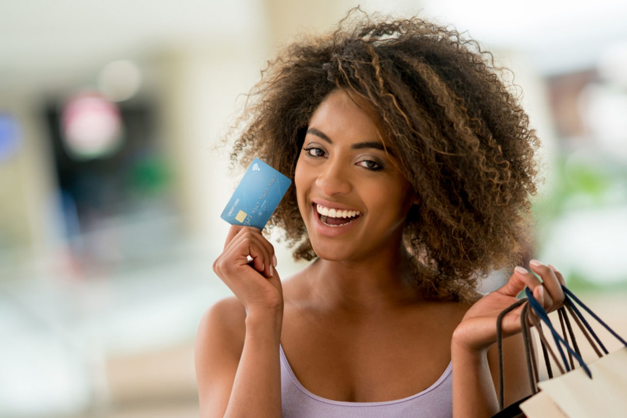 Junge Frau mit Karte und Einkaufstauschen in der Hand