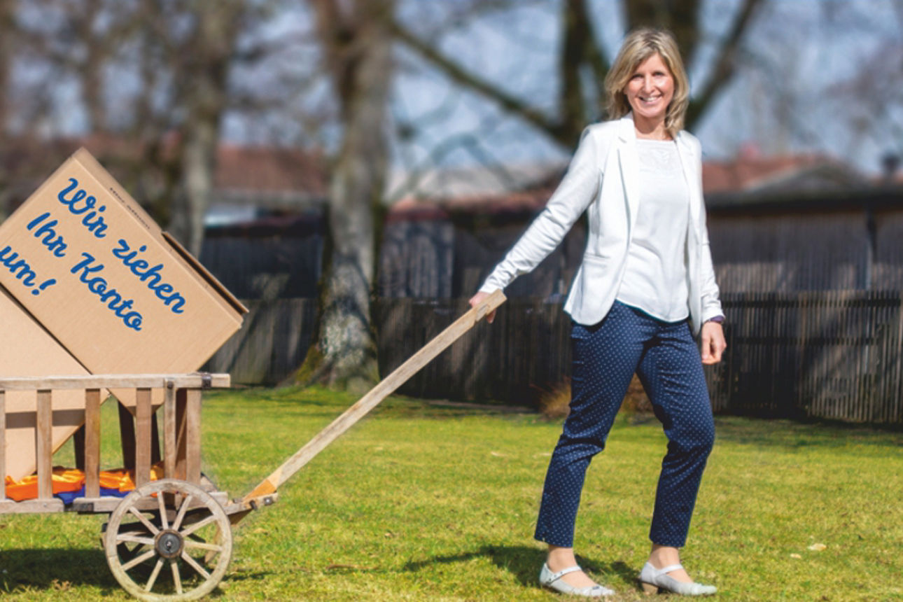 Zwei Frauen ziehen Leiterwagen mit Umzugskartons