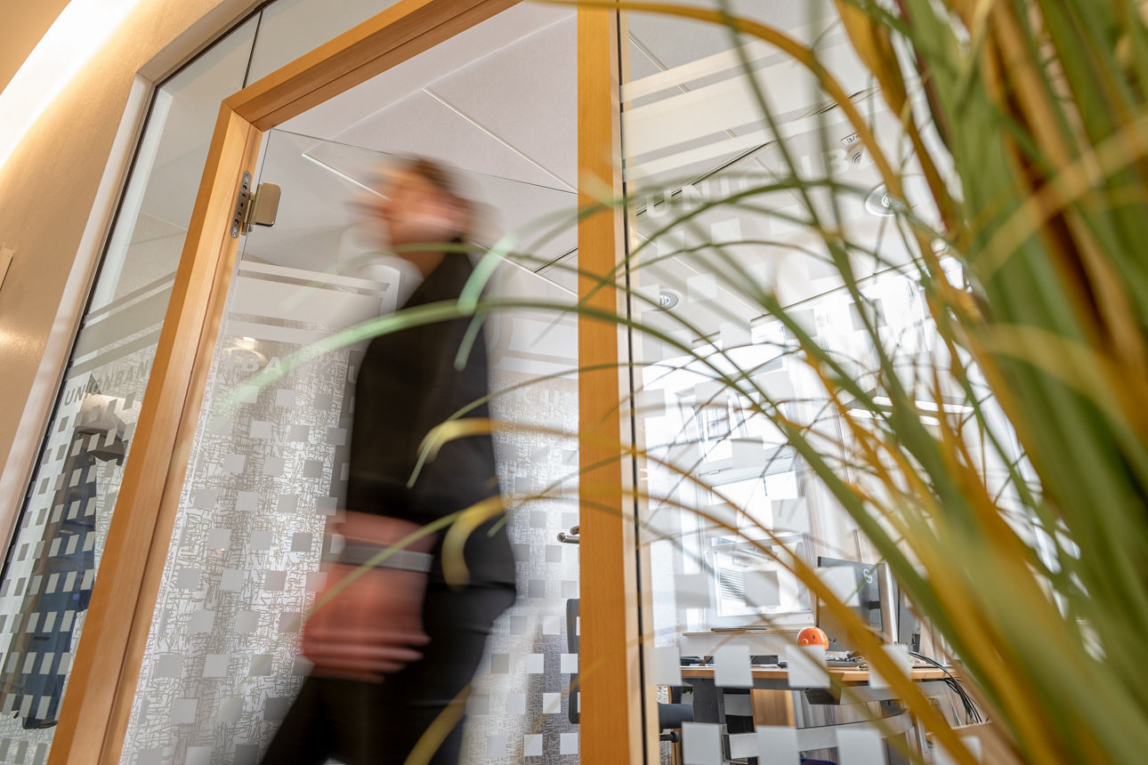 Frau geht durch eine Glastür