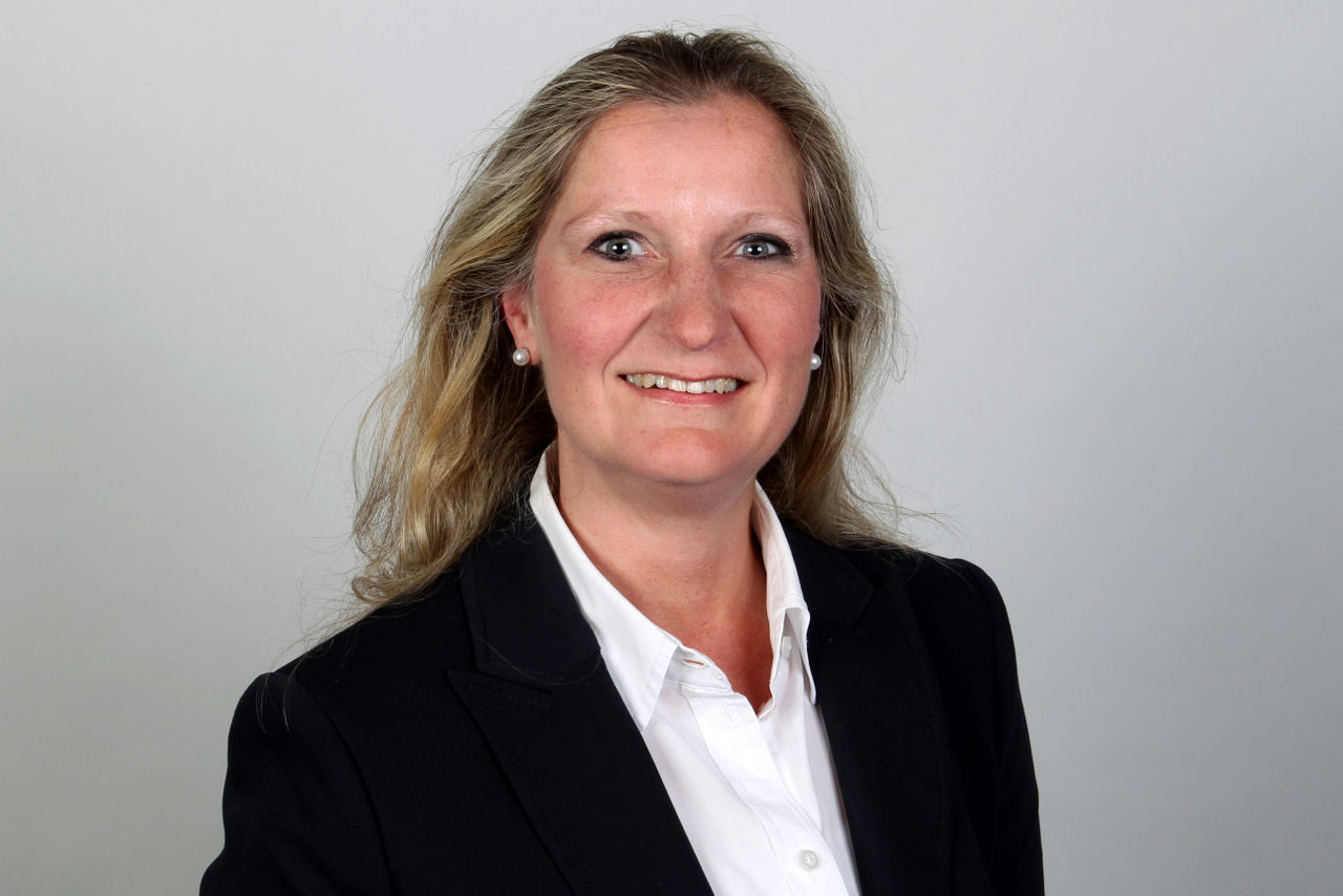 Eine lächelnde Frau schaut in die Kamera.