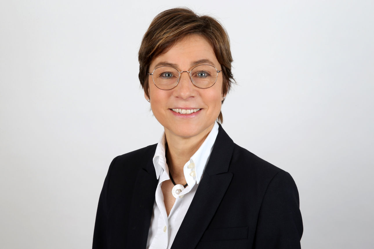 Ein lächelnder Frau schaut in die Kamera.