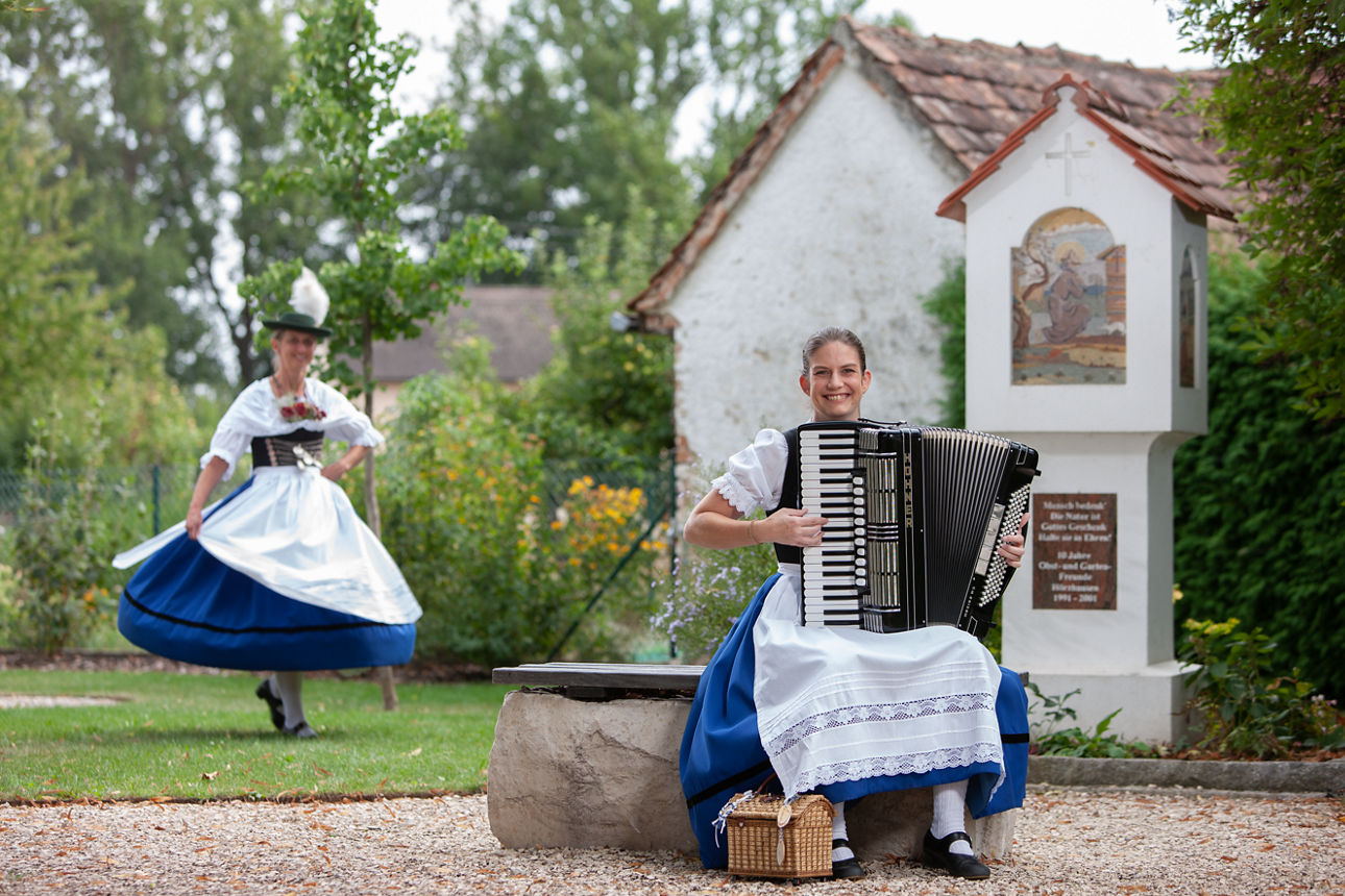 zwei Frauen in traditioneller Tracht spielen ein Musikinstrument