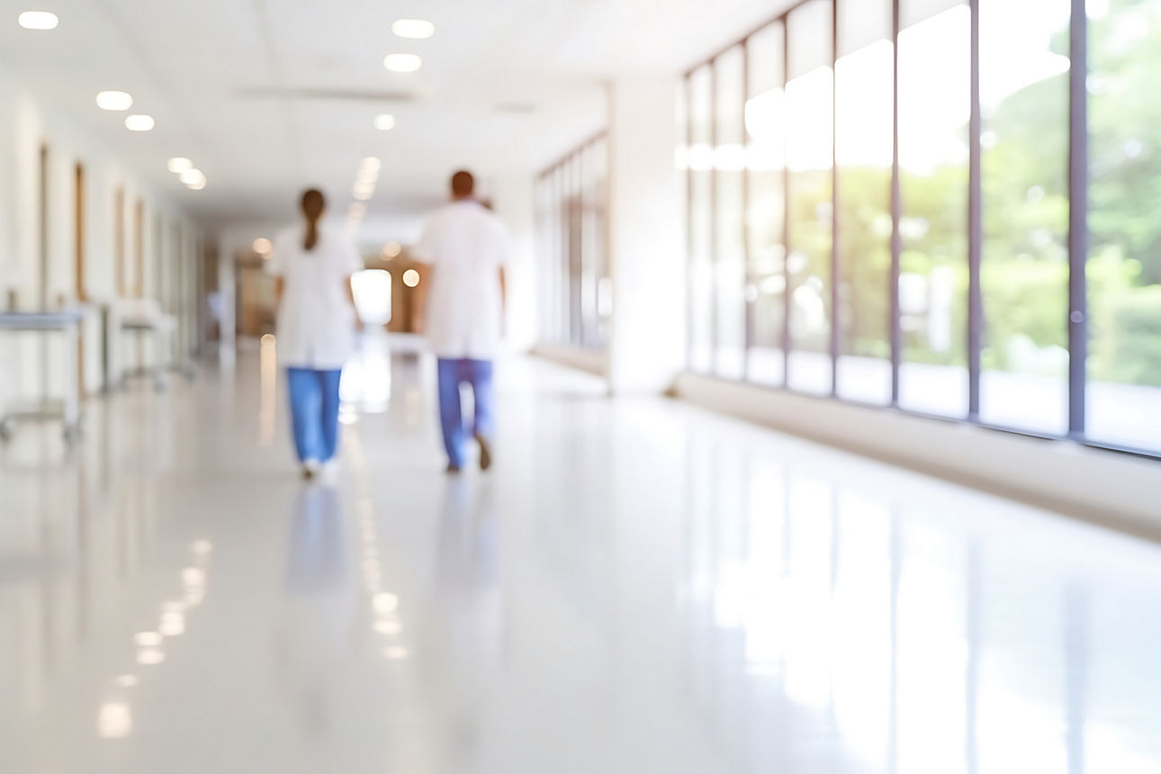 sMedizinisches Fachpersonal geht einen Krankenhausflur entlang.