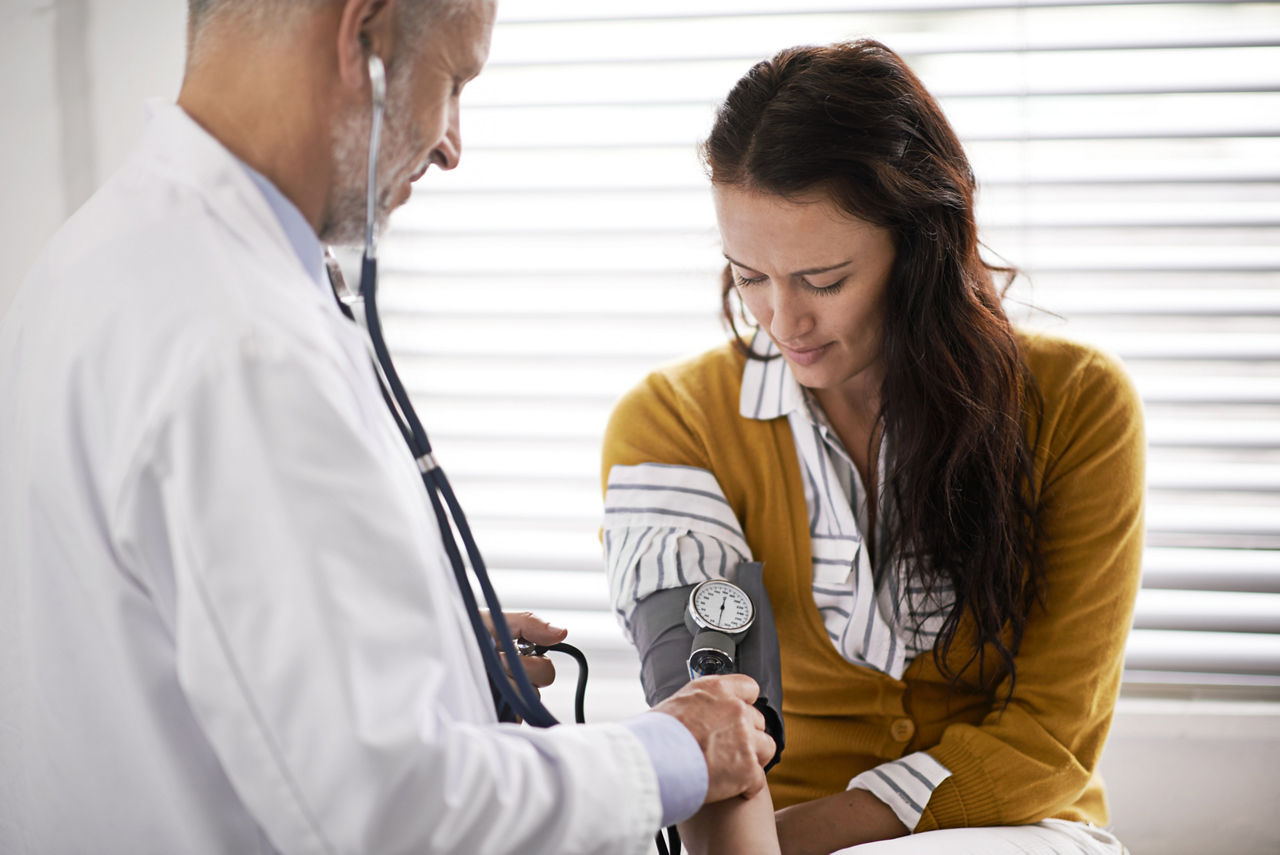 Arzt, der den Blutdruck eines Patienten überprüft