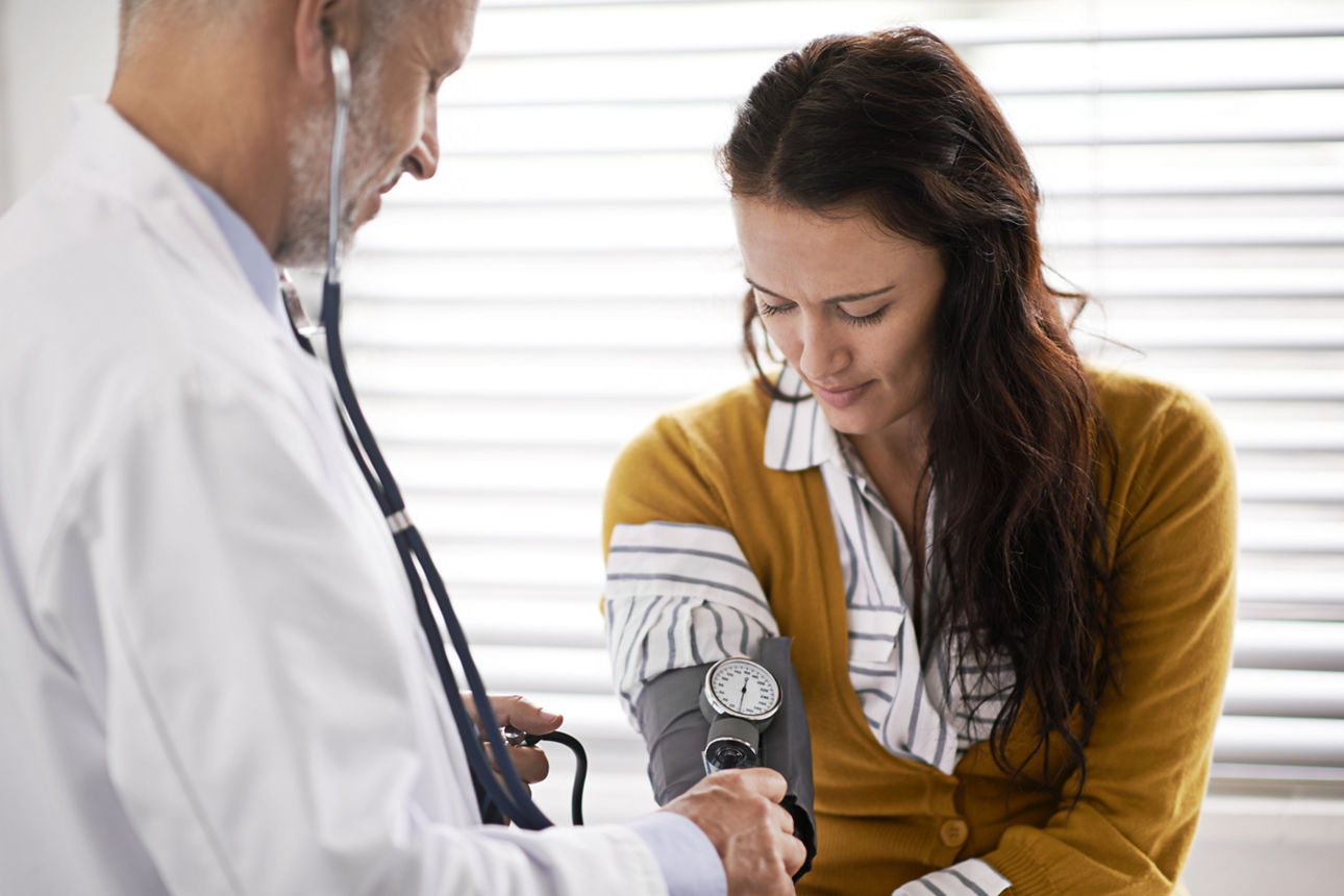 Arzt, der den Blutdruck eines Patienten überprüft