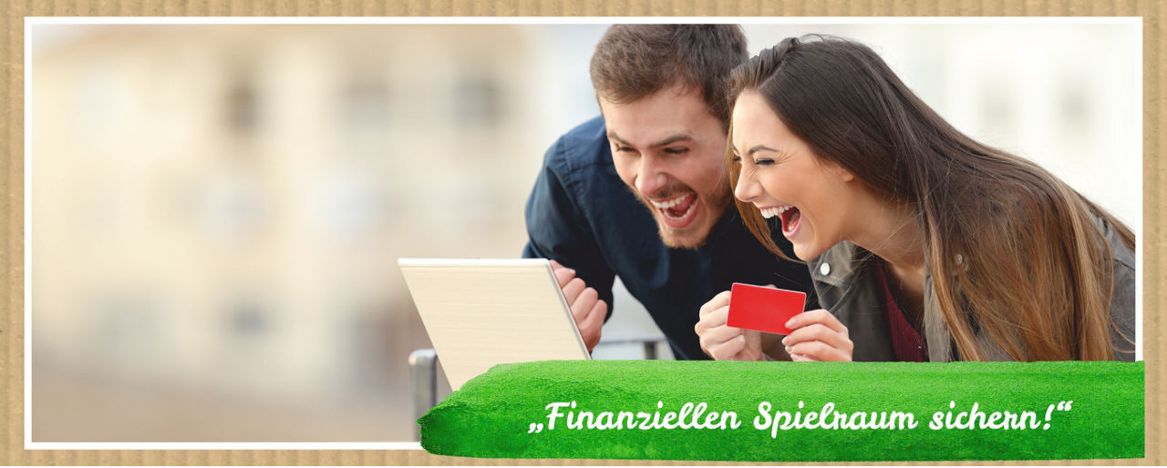 Zwei lachende Personen vor dem Laptop