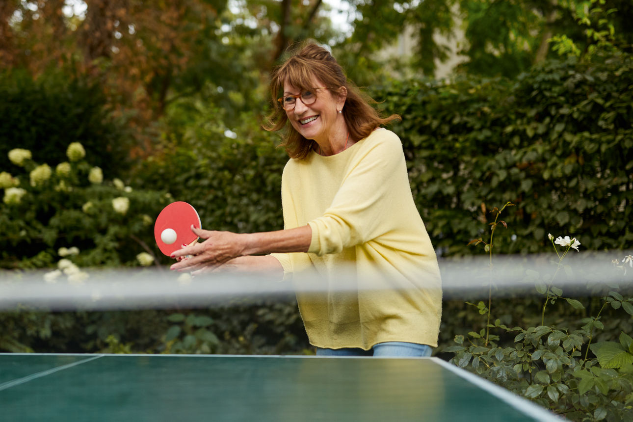 Eine ältere Frau spielt Tischtennis.