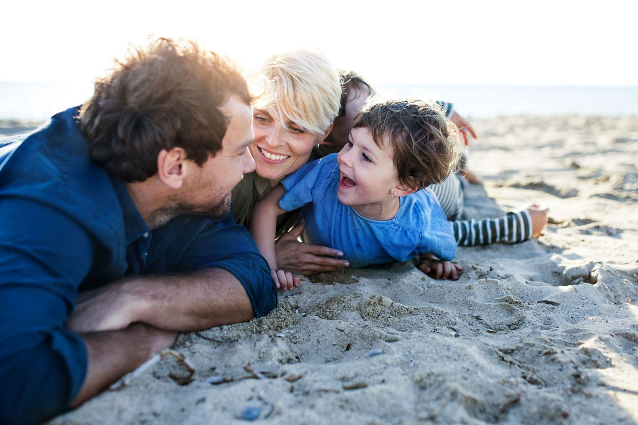 glückliche Familie liegt am Strand