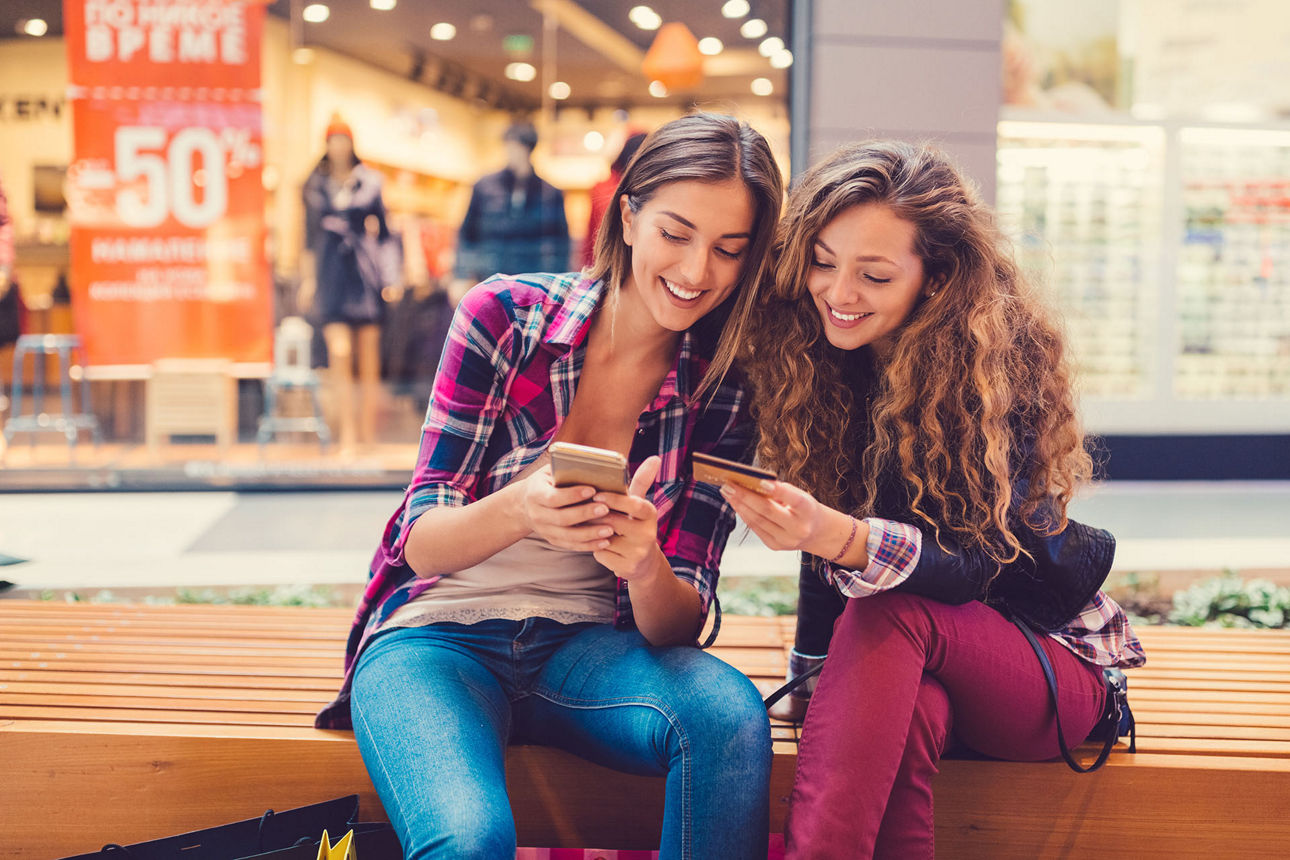 Zwei Frauen schauen auf ein Smartphone.