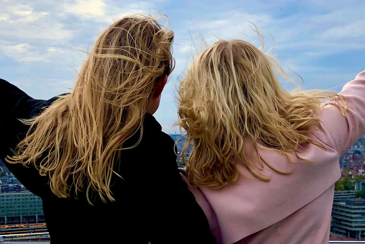 Zwei Frauen mit blonden Haaren drehen der Kamera den Rücken zu