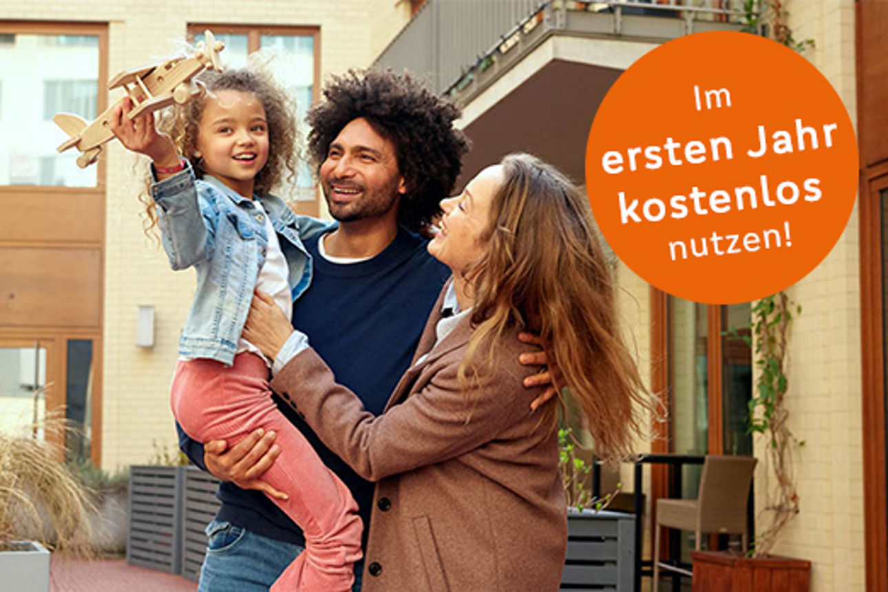 Ein Kind spielt mit einem Modelflugzeug und sitzt auf dem Arm der Eltern