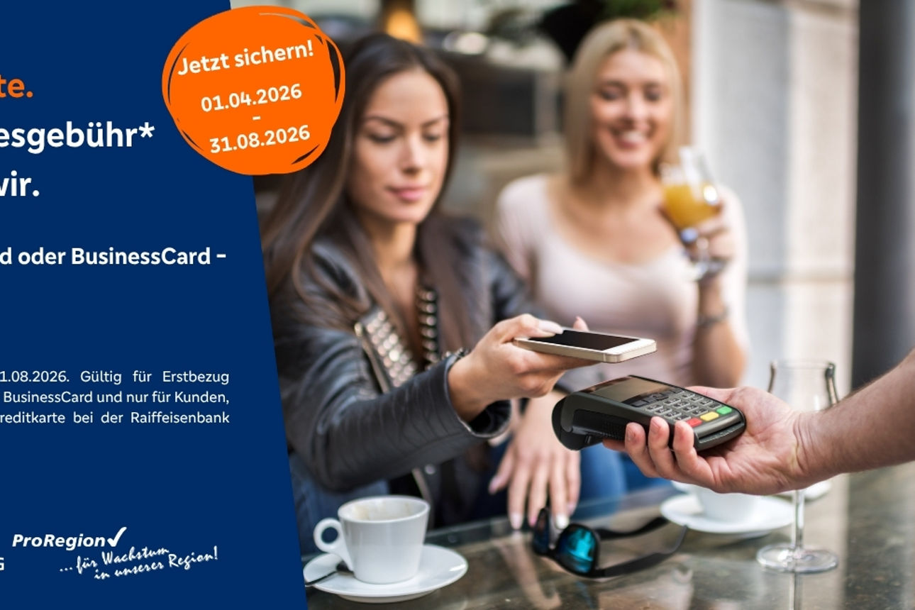 zwei junge Damen sitzen vor einem Cafe und bezahlen über Smartphone