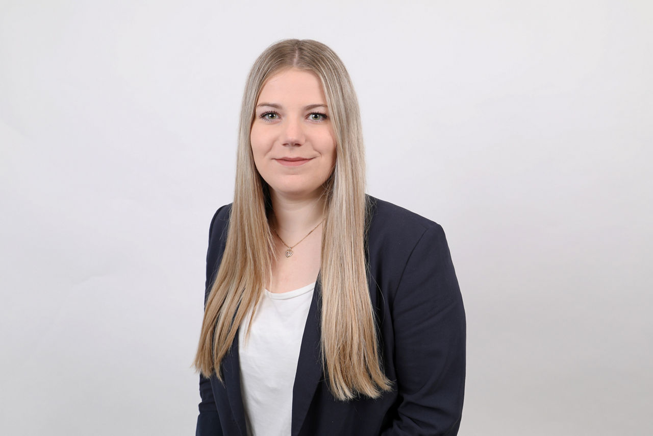 Mitarbeiterin, Mareike Krieg, vor weißem Hintergrund lächelt in die Kamera