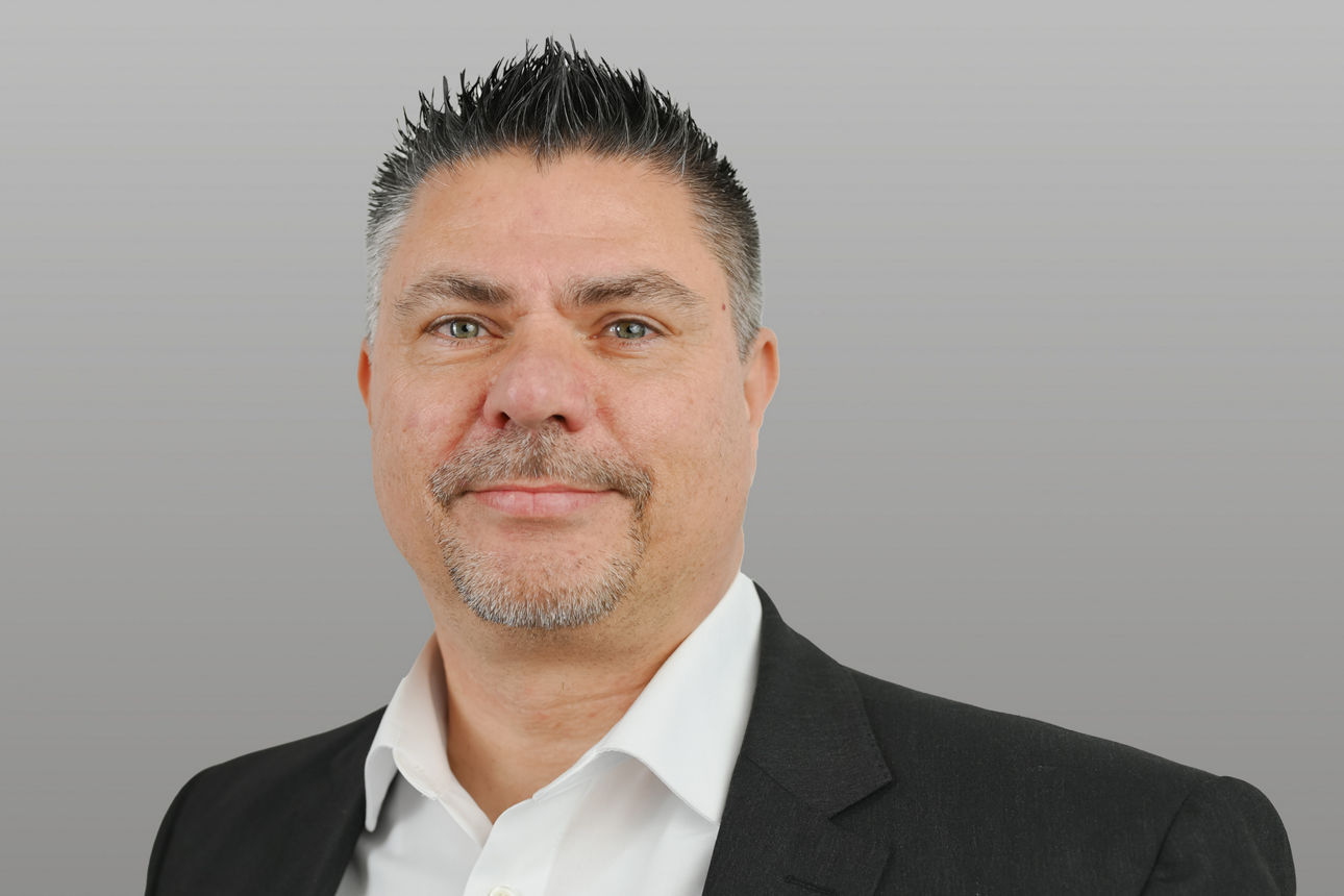 Firmenkundenberater Markus Krix vor grauen Hintergrund