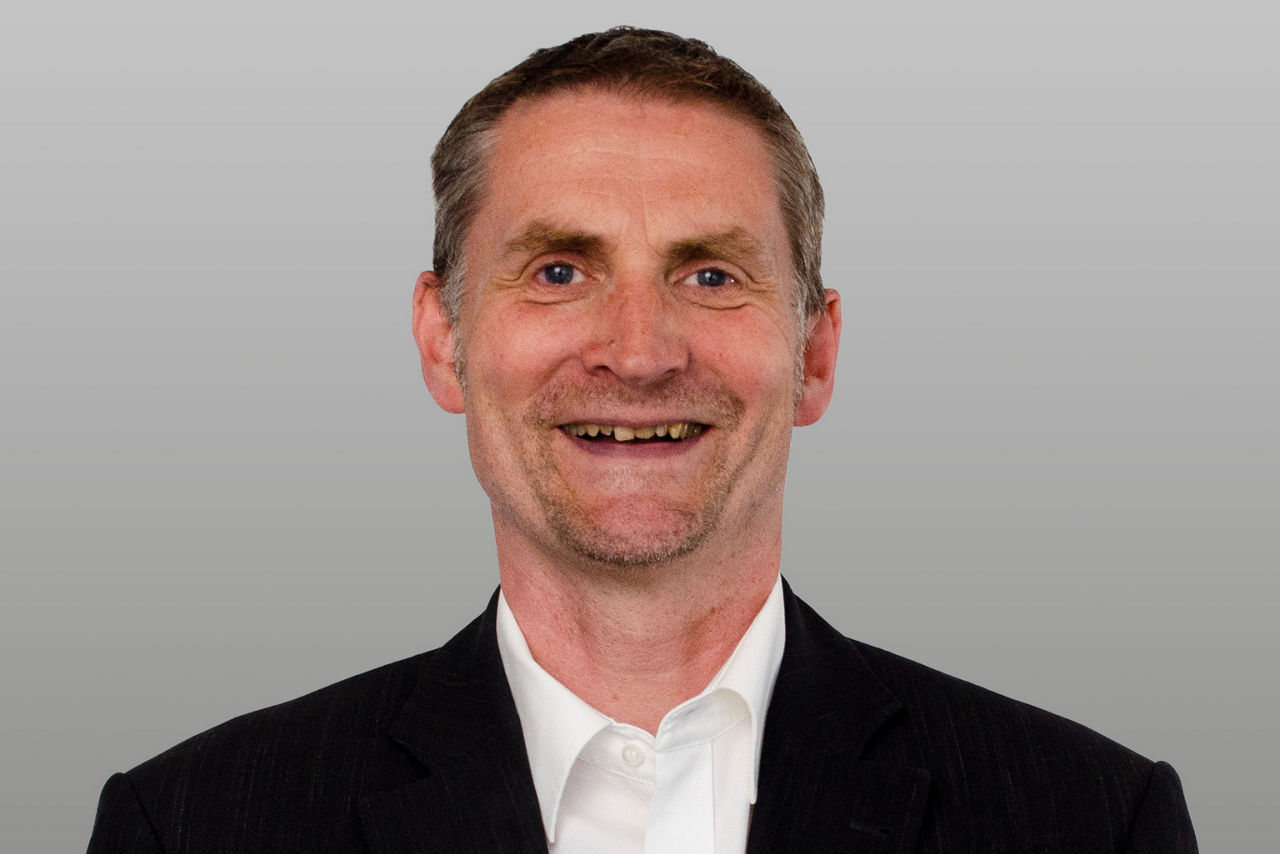 Privatkundenberater Guido Kroll vor grauen Hintergrund