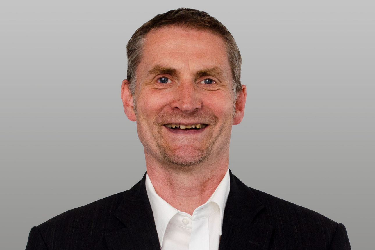 Privatkundenberater Guido Kroll vor grauen Hintergrund