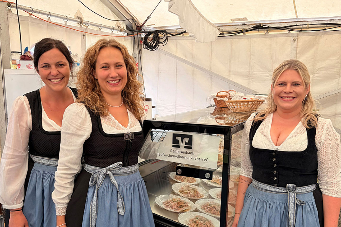 Drei Frauen im Dindl stehen vor einer Kühltheke
