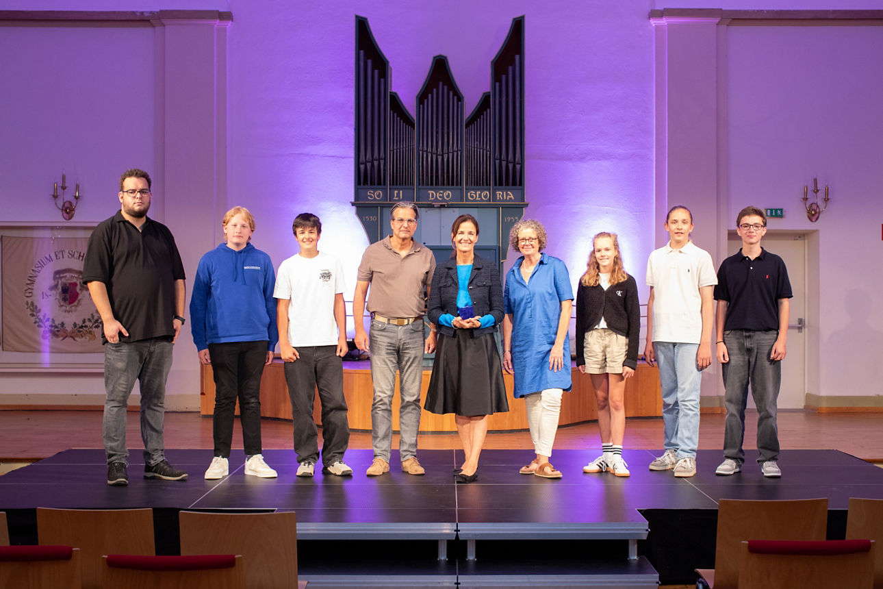 Eine Gruppe Menschen auf einer Bühne vor einer Orgel