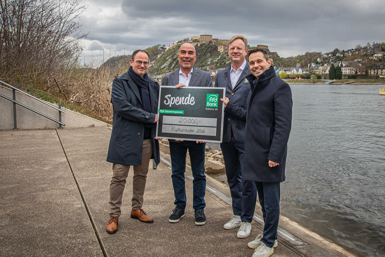 Mehrere Personen halten einen Scheck