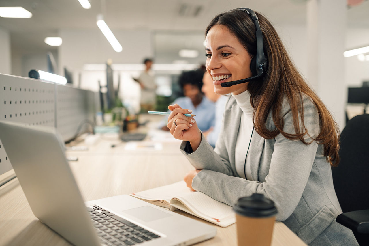 Eine Frau telefoniert im Büro mit ihrem Headset